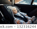 Baby sitting in an infant car seat, safety travelling by car with little child. Little baby fastened with seat belt in safety car seat. Road trip lifestyle child care transportation rear-facing. 132316244