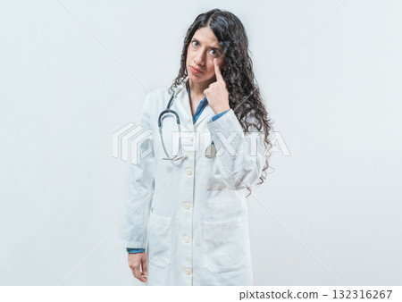Suspicious female doctor looking you isolated. Suspicious young doctor pointing at eye, isolated. Suspicious female doctor looking you isolated. Suspicious young doctor pointing at eye, isolated. 132316267