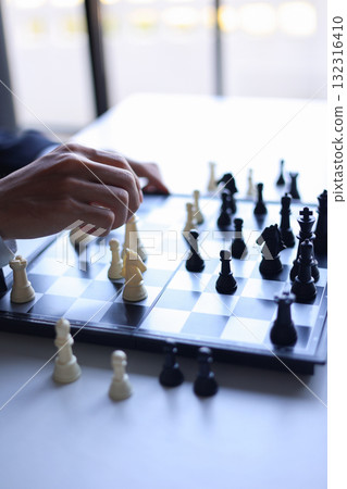 Businessman playing chess game; business strategy, leadership and management concept. 132316410