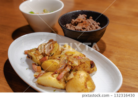 A home-style dinner with sautéed bacon and potatoes as the main dish 132316430