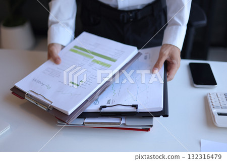 Businessman working in office reading documents analyze data for project planning. Businessman working in office reading documents analyze data for project planning. 132316479