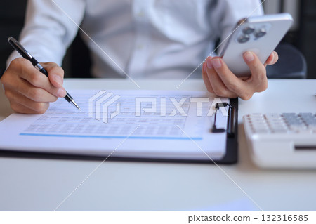 Businessman working in office using smartphone Businessman working in office using smartphone 132316585