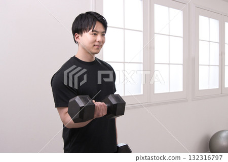 A man in his 20s doing muscle training with dumbbells A man in his 20s doing muscle training with dumbbells 132316797
