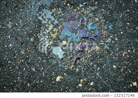 Oil spill on wet asphalt surface showing iridescent colors and creating abstract texture. Oil spill on wet asphalt surface showing iridescent colors and creating abstract texture. 132317146