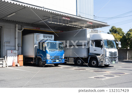 Loading and unloading area of a logistics warehouse and two trucks Loading and unloading area of a logistics warehouse and two trucks 132317429