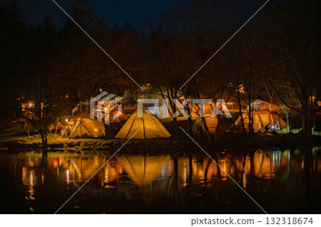 The light of the tent reflected on the water at night 132318674