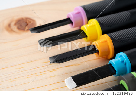 Close-up of a wooden board and the cutting edge of a chisel 132319486