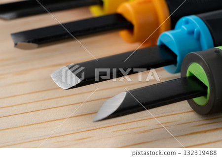 Close-up of a wooden board and the cutting edge of a chisel 132319488