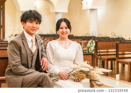 Wedding hall, bride and groom sitting on a bench in the chapel (Virgin aisle, church, chapel) Wedding hall, bride and groom sitting on a bench in the chapel (Virgin aisle, church, chapel) 132319548