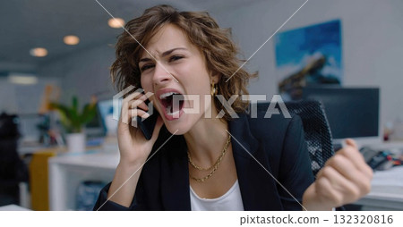 A person is excitedly celebrating business success on a phone call in an office setting. The energy reflects a significant achievement, embodying victory and team spirit, while holding a trophy. 132320816