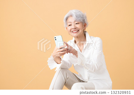 Senior woman with gray hair looking at her smartphone 132320931