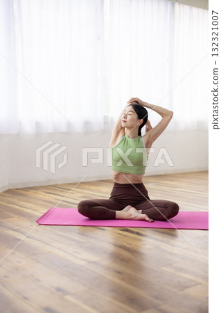 Middle-aged woman doing yoga poses on a yoga mat Middle-aged woman doing yoga poses on a yoga mat 132321007
