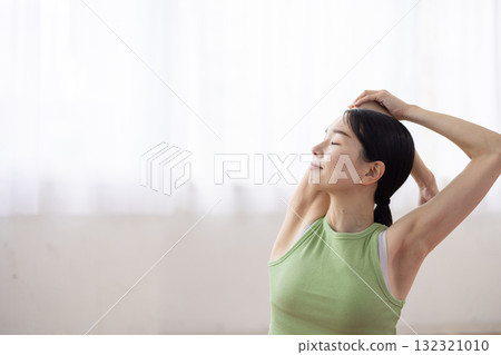 Middle-aged woman doing yoga poses on a yoga mat 132321010
