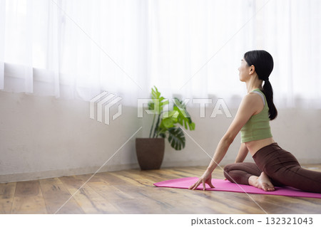 Middle-aged woman doing yoga poses on a yoga mat Middle-aged woman doing yoga poses on a yoga mat 132321043