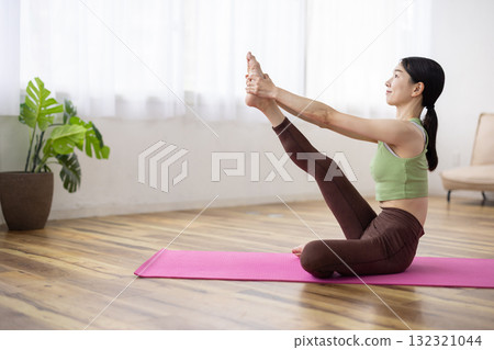 Middle-aged woman doing yoga poses on a yoga mat Middle-aged woman doing yoga poses on a yoga mat 132321044