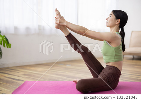 Middle-aged woman doing yoga poses on a yoga mat Middle-aged woman doing yoga poses on a yoga mat 132321045