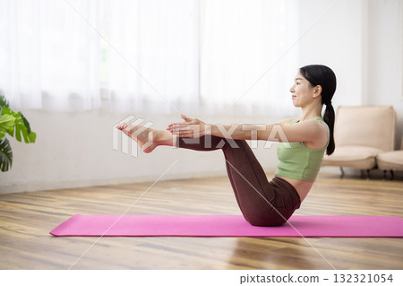 Middle-aged woman doing yoga poses on a yoga mat Middle-aged woman doing yoga poses on a yoga mat 132321054