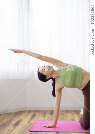 Middle-aged woman doing yoga poses on a yoga mat Middle-aged woman doing yoga poses on a yoga mat 132321063