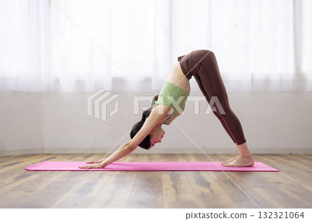 Middle-aged woman doing yoga poses on a yoga mat Middle-aged woman doing yoga poses on a yoga mat 132321064