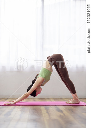 Middle-aged woman doing yoga poses on a yoga mat 132321065