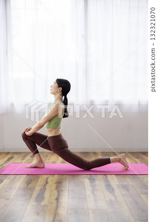 Middle-aged woman doing yoga poses on a yoga mat 132321070