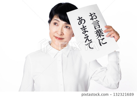 A senior woman holding a piece of paper with "I'll take you up on your offer" written on it in one hand and looking away A senior woman holding a piece of paper with "I'll take you up on your offer" written on it in one hand and looking away 132321689