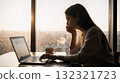 Businesswoman working on laptop at sunset in modern office enjoying city view 132321723