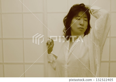 A woman relaxing in a white long shirt after taking a bath A woman relaxing in a white long shirt after taking a bath 132322405