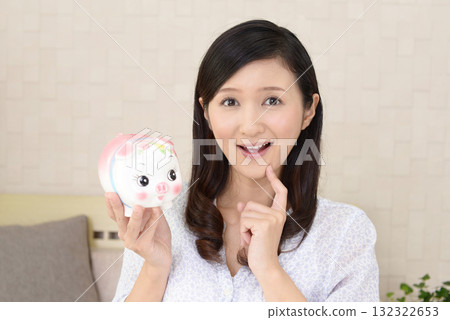 有豬的存錢罐的一名婦女 132322653