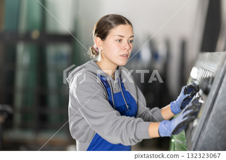 Young woman operates control panel in factory 132323067