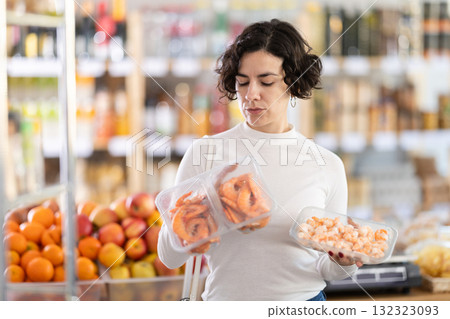 In store, woman near counter are looking at prawns 132323093