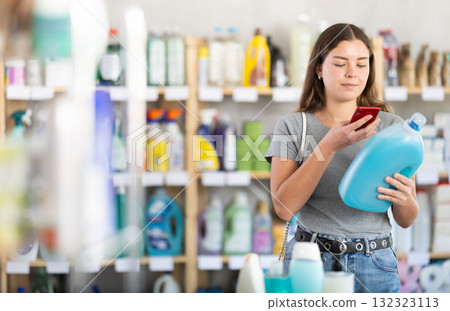 Young woman scanning qr code for detergent Young woman scanning qr code for detergent 132323113