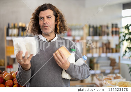 Adult man choosing dairy products in grocery store Adult man choosing dairy products in grocery store 132323178