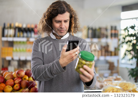 Man scanning the barcode of a package of olives Man scanning the barcode of a package of olives 132323179