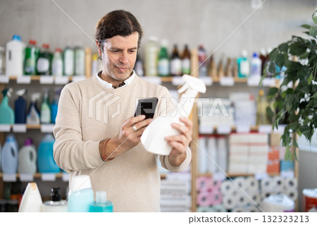 Adult man scanning qr code for cleaning spray Adult man scanning qr code for cleaning spray 132323213