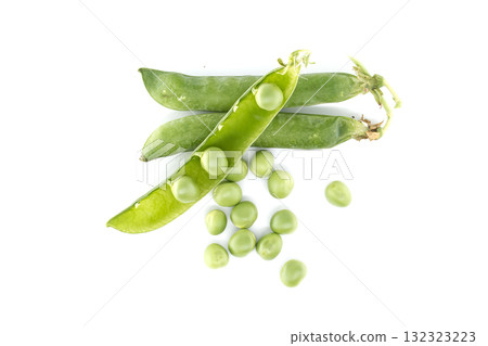 An overhead view showcases vibrant green peas and open pods on white surface, ready to be harvested 132323223