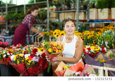 Young girl holding bouquet of flowers in large plants market Young girl holding bouquet of flowers in large plants market 132323231