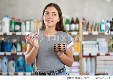 Interested young woman picking beauty products in store Interested young woman picking beauty products in store 132323271