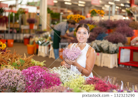 Girl customer in flower shop chooses dry flowers to form ikebana 132323290