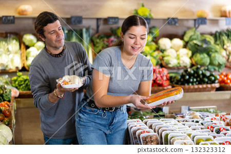 Man and woman choose papaya and roots in shop Man and woman choose papaya and roots in shop 132323312