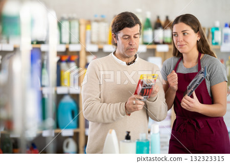 Saleswoman offers a man to buy razor for shaving Saleswoman offers a man to buy razor for shaving 132323315