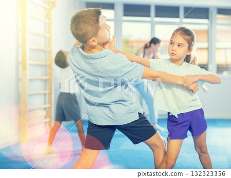 Boys and girls in gym perform basic elements of krav maga self-defense system. 132323356