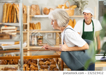 Elderly woman choosing pastries in bakery Elderly woman choosing pastries in bakery 132323412