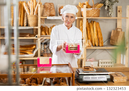 Elderly woman seller weighs piece of cake 132323453