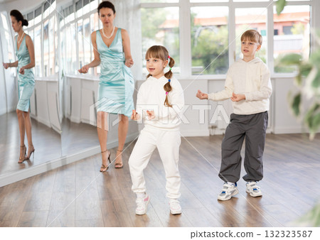 Tween girl and boy snapping fingers while rehearsing jazz style dance in studio Tween girl and boy snapping fingers while rehearsing jazz style dance in studio 132323587