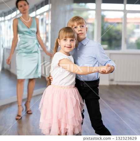 Tween girl and boy practicing waltz in dance hall with female mentor Tween girl and boy practicing waltz in dance hall with female mentor 132323629