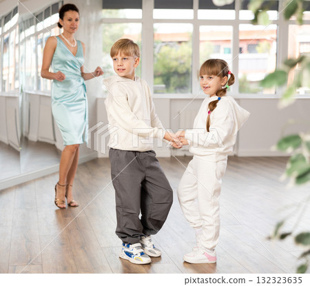 Boy and girl in sport wear train to dance contemporary vigorous rumba during classes. Boy and girl in sport wear train to dance contemporary vigorous rumba during classes. 132323635