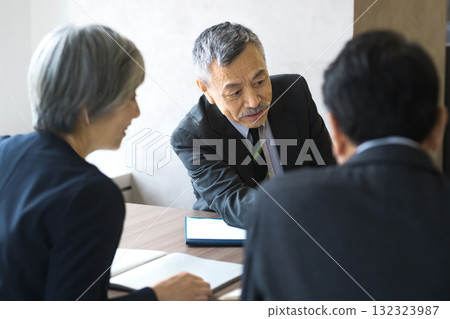 Senior businessmen explaining enthusiastically at a meeting (business negotiation, three people, serious) Senior businessmen explaining enthusiastically at a meeting (business negotiation, three people, serious) 132323987