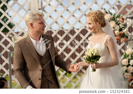 Couple exchanges vows in a beautiful outdoor wedding ceremony Couple exchanges vows in a beautiful outdoor wedding ceremony 132324381