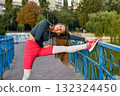 Young Woman Stretching on a Bridge in a Park During Autumn Morning 132324450